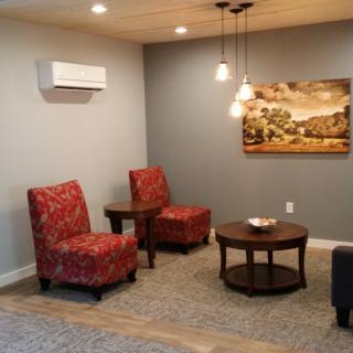 Cozy living room with red chairs, a round table, and decorative lighting.