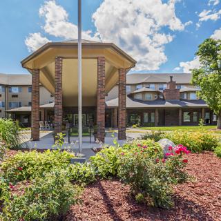 Front view of a building with landscaped gardens and a clear blue sky.