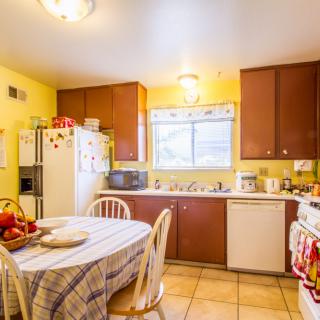 A cozy kitchen with wooden cabinets and a dining table set for two.