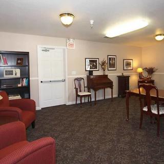 A cozy living room featuring a piano, bookshelves, and comfortable seating.
