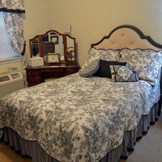 A cozy bedroom with a vintage-style bed and a matching vanity table.