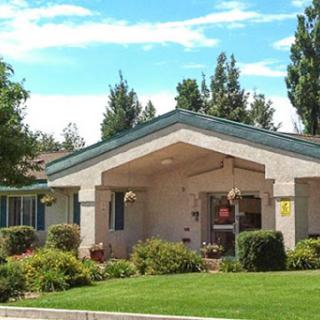 A charming residential house surrounded by well-maintained landscaping and trees.