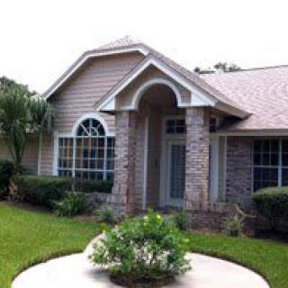 A charming residential house with a well-maintained front yard and a welcoming entrance.