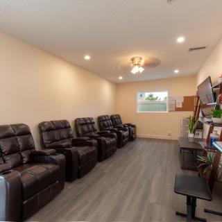 A modern waiting room with comfortable recliner chairs and elegant lighting.