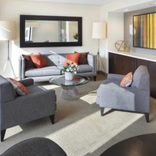 A modern living room with a sofa, armchairs, and a coffee table.