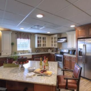 A modern kitchen with a central island, stainless steel appliances, and wooden cabinets.