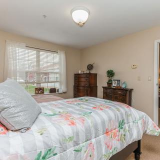 A cozy bedroom with a floral bedspread and wooden furniture.