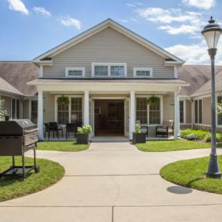 A charming residential house with a welcoming front porch and well-maintained landscaping.