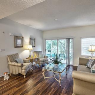 A cozy living room with elegant furniture and large windows offering natural light.