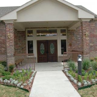 A welcoming entrance to a beautifully landscaped building.