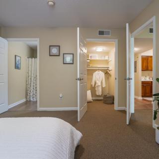 A cozy bedroom with open doors leading to a closet and bathroom.