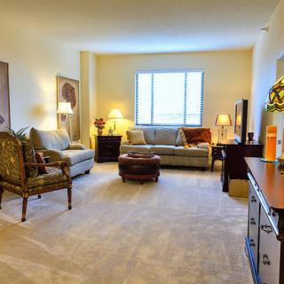 Spacious and well-lit living room with comfortable seating and elegant decor.