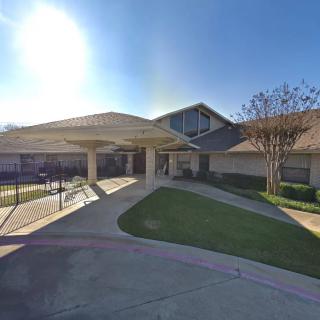 A sunny view of a building entrance with a landscaped path.