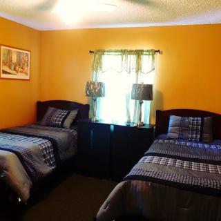 A cozy bedroom with twin beds and warm orange walls.