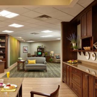 A modern open-plan living room and kitchen area with wooden cabinets and cozy furnishings.