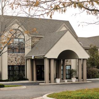 A building with a grand entrance featuring columns and a peaked roof.