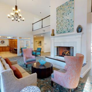 A stylish and cozy living room with a fireplace, comfortable seating, and elegant decor.