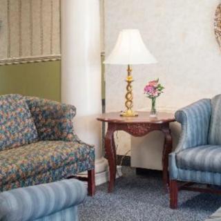 A cozy living room with two sofas, a wooden table, and a decorative lamp.