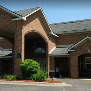 A brick building with an arched entrance and well-maintained landscaping.