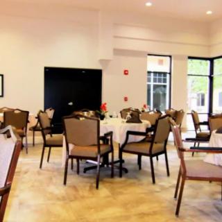 A well-lit dining area with multiple tables and chairs arranged neatly.
