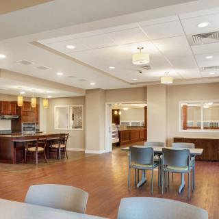 A modern dining and kitchen area with ample seating and contemporary lighting.