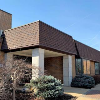 Exterior view of a brick office building with landscaped bushes.