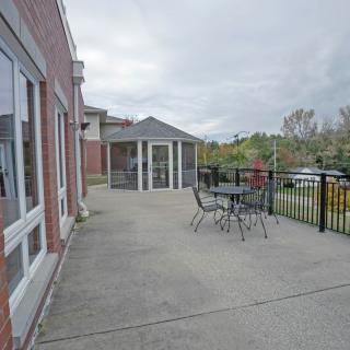 An outdoor patio with a table and chairs, adjacent to a building under an overcast sky.