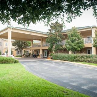 A hotel building with a covered entrance and landscaped surroundings.