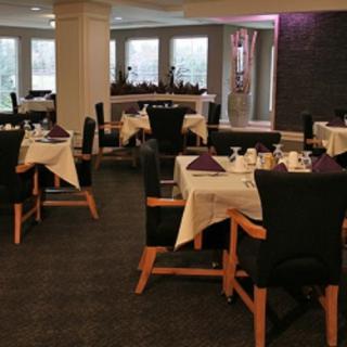 An elegant dining area with neatly set tables and chairs, ready for guests.