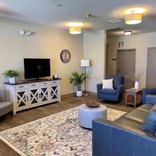 A modern living room featuring comfortable seating, a TV stand, and stylish decor elements.