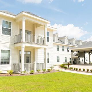 A modern residential building with a well-maintained lawn and bright exterior.