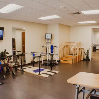 A spacious rehabilitation center equipped with various exercise tools and a small staircase for physical therapy exercises.
