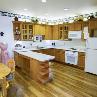 A modern kitchen featuring wooden cabinets, a central island, and white appliances.