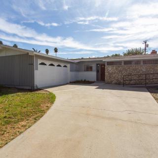 A view of a residential house with a driveway and clear sky.