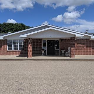 A welcoming view of a brick building under a clear blue sky.