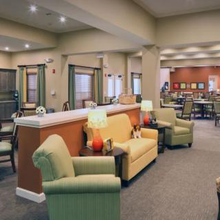 A comfortable lounge area with armchairs, sofas, and warm lighting.