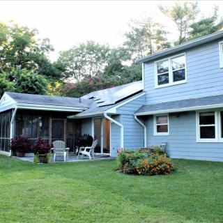 A suburban house with a well-maintained lawn and a screened porch.