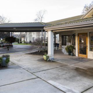 An exterior view of a building entrance with an awning and driveway.