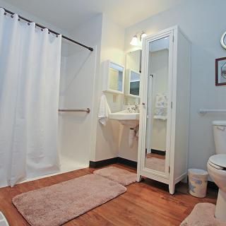 A modern bathroom with a shower, cabinet, and various amenities.