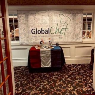 A Global Chef event setup with a decorative banner and table adorned with flags.