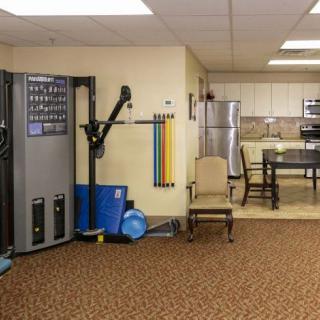 A small fitness area with exercise equipment and a kitchen corner.