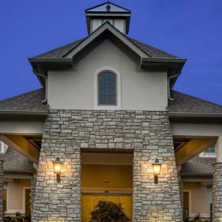 A stone facade building with illuminated entrance during the evening.