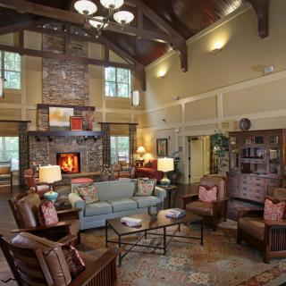 A cozy rustic living room with a stone fireplace and wooden beams.