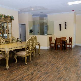 A spacious dining room with elegant furniture and wooden flooring.