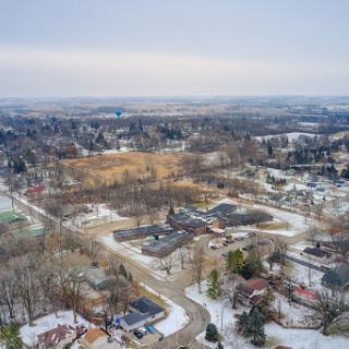 An aerial view of a suburban area blanketed in snow, showcasing the quiet beauty of winter in a small town.