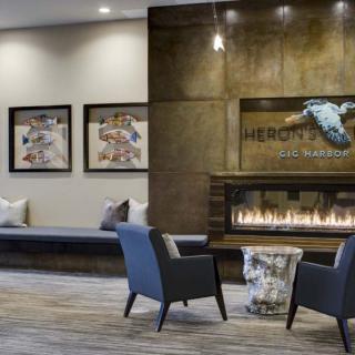 A modern hotel lobby featuring a cozy seating area with a fireplace and decorative artwork.
