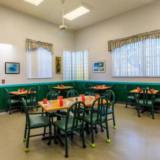 A cozy dining area with green accents and neatly arranged tables.