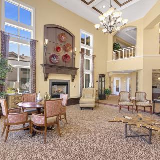 A spacious and elegantly designed lobby area with comfortable seating, a fireplace, and abundant natural light.