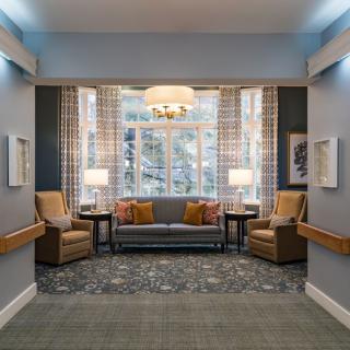 A cozy living room with a sofa, armchairs, and a chandelier illuminating the space.