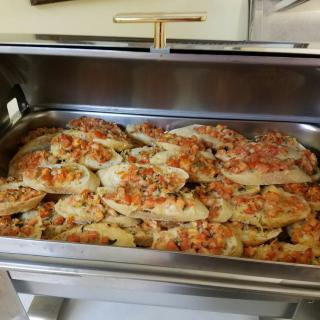 A tray of cooked chicken breast topped with a mix of vegetables ready for serving.